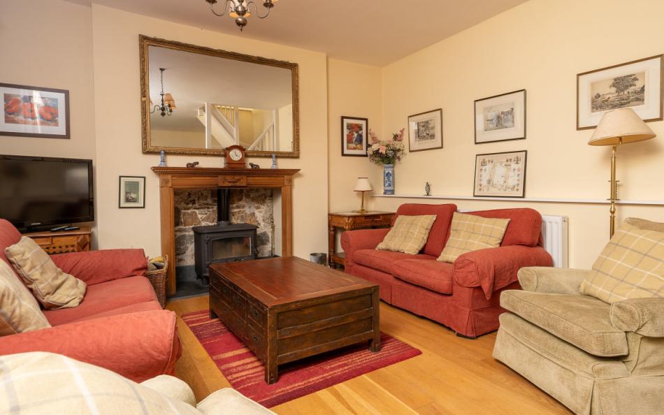 The lounge area with wood-burning stove at Holne Chase Carriage House