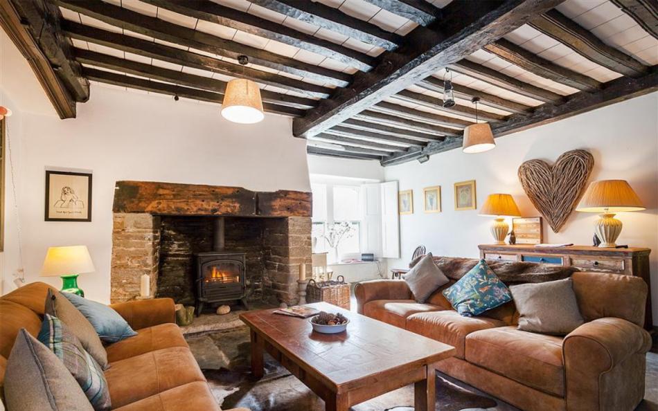 Snug with beamed ceiling, slate floors, comfy sofas and log burner at Higher Sutton