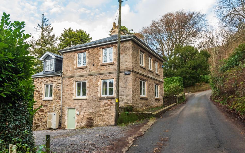 The outside of the lodge off the lane, showing the parking at Clanacombe Lodge 