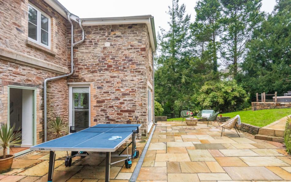 The patio area showing the table tennis table and gardens at Clanacombe Lodge 