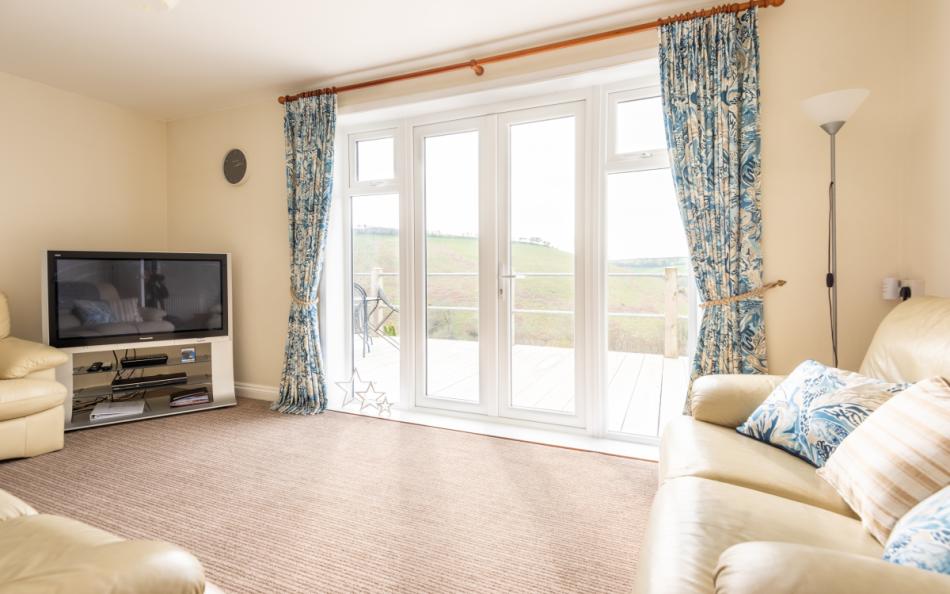 Comfortable bright lounge leading to decked terrace at Hillsview