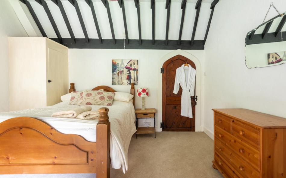 bedroom with exposed beams at Treverbyn Vean Lodge & Stable