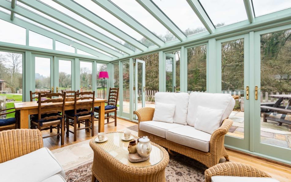 Enjoy the lovely waterside views from the conservatory at Perchwood Shippon