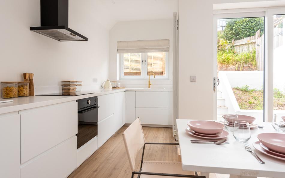 Modern kitchen dining room with French windows leading to the garden at Craiglands