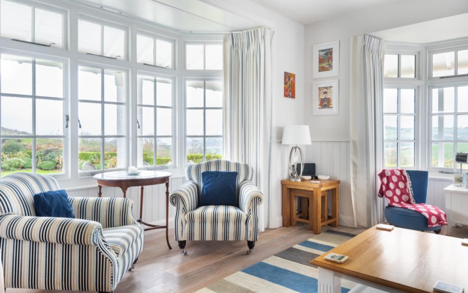 chairs by window with sea views at Pipers Bench & Apartment
