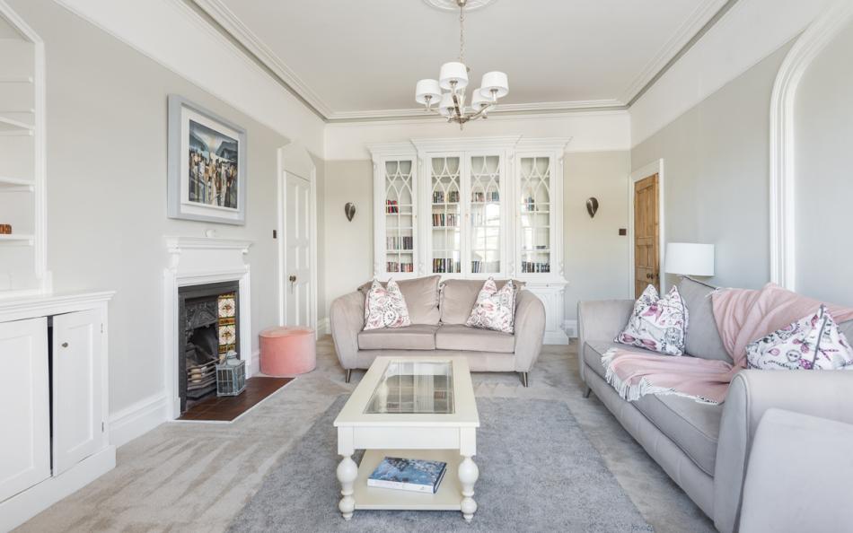 Spacious and tastefully furnished living room with feature fireplace at Halcyon House