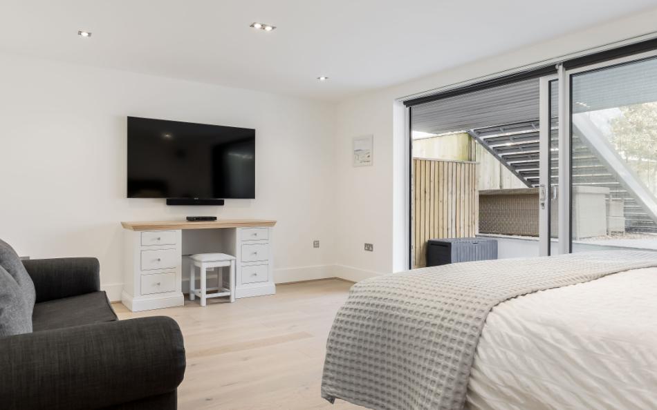 Bedroom with large TV at Leeward