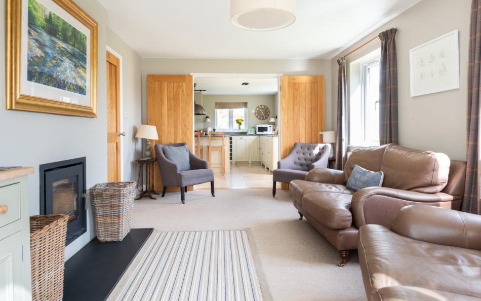 Spacious living room with log burner at Clover Cottage