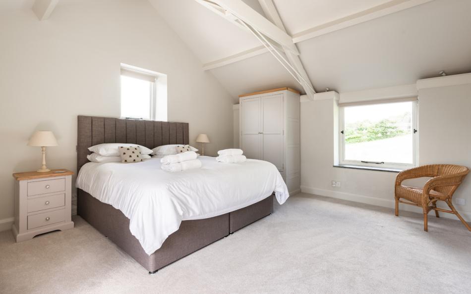 The spacious master bedroom with views over the paddock at Farthingfield 