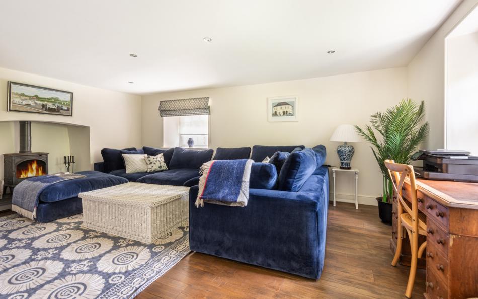 Snug/TV room with log burner and desk space at Bow Bridge House 