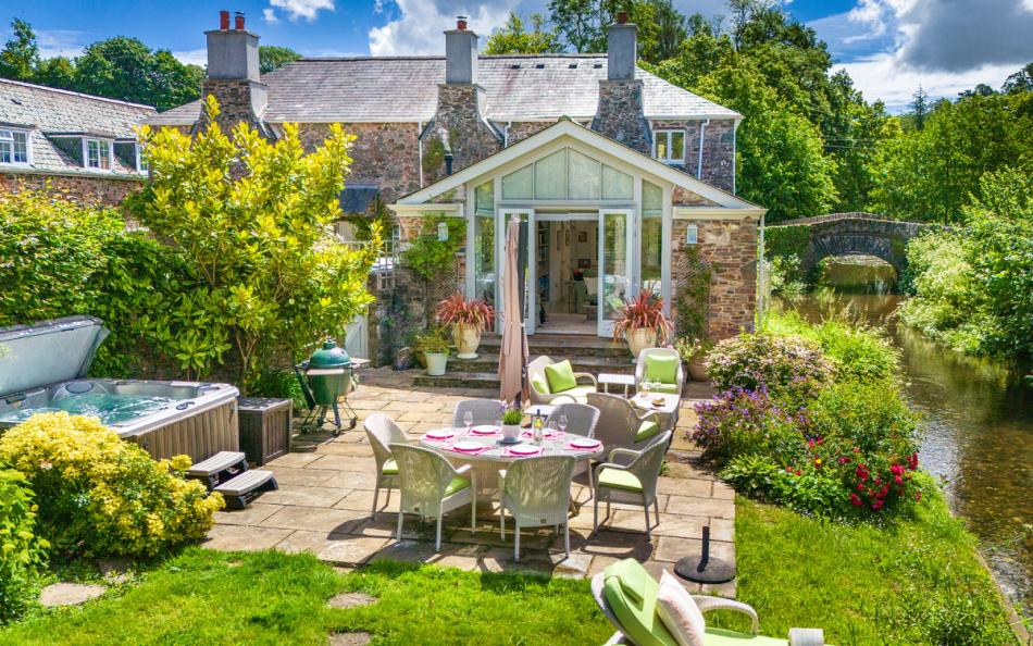 Large rear patio with hot tub, BBQ and table and chairs at Bow Bridge House 