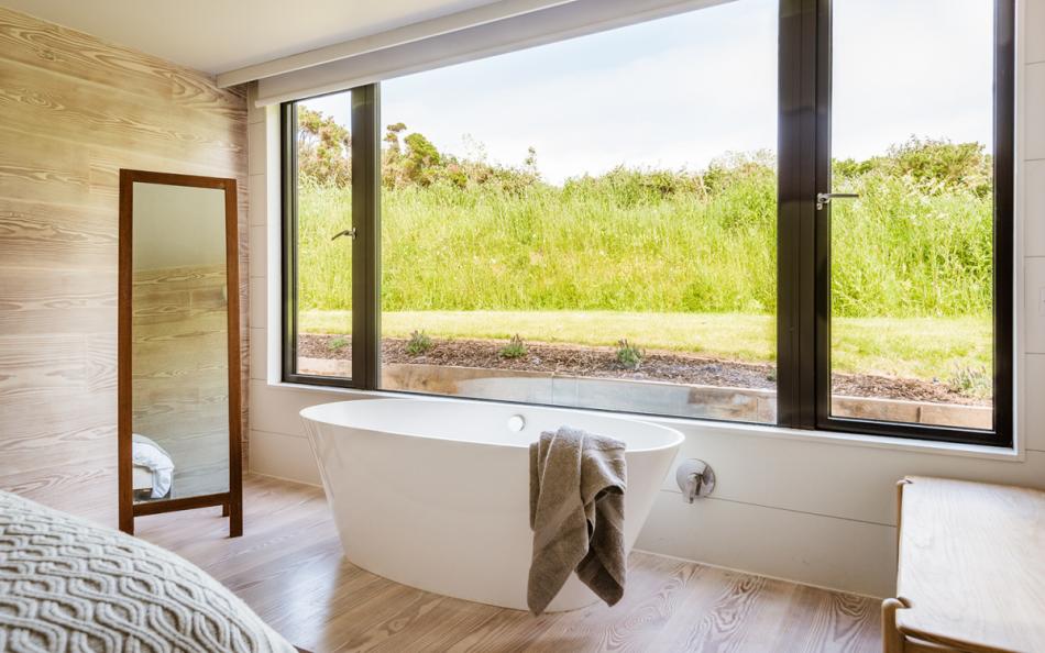 A freestanding bath sits in the master bedroom window at Huccombe Farmhouse 