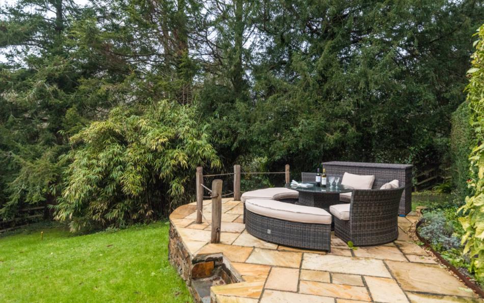 Patio at the top of the garden with garden furniture at Clanacombe Lodge 