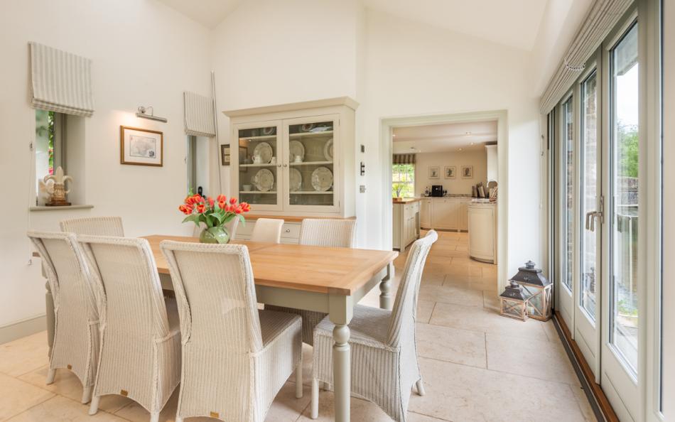 Dining area and french doors to sunroom balcony at Bow Bridge House 